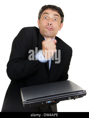 Esasperati uomo che fa un pugno sul suo chiuso il computer portatile che egli è in possesso di io la sua mano mentre smorfie alla fotocamera Foto Stock