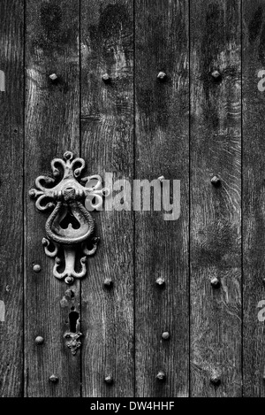 Quercia antica porta della chiesa e di elementi in ferro battuto di gestire i dettagli. In Inghilterra. In bianco e nero Foto Stock