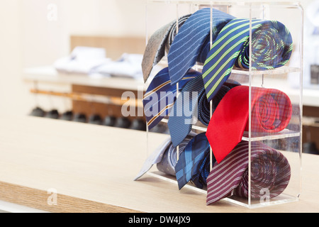 Set di arrotolato collo legami sul ripiano in plastica in un negozio Foto Stock