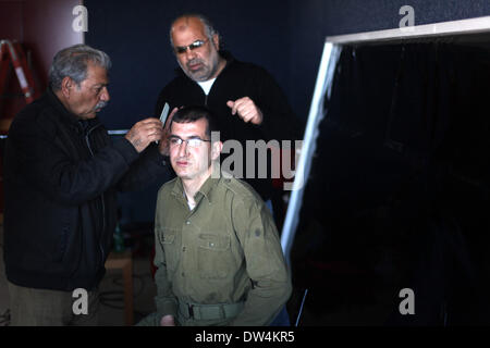 La striscia di Gaza, Territori palestinesi. Il 27 febbraio, 2014. Attore Mahmoud Karira, che interpreta il ruolo di Gilad Schalit, trucco ha applicato da un assistente durante le riprese di un film che viene realizzato nella Striscia di Gaza chiamato 'Perdere Shalit'. "Perdere Schalit', attualmente in fase di riprese nel territorio bloccato, è il primo di una prevista serie in tre parti sulla 2006 cattura del soldato israeliano Gilad Schalit da uomini armati alleati con il militante islamico Hamas movimento. Le parti due e tre illustrerà Schalit il momento in cattività e il suo 2011 swap per centinaia di prigionieri palestinesi detenuti da Israele. (Credito Immagine: © Majdi Fathi/NurPhoto/ZUM Foto Stock