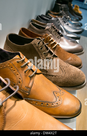 Una selezione di nuovi mens scarpe in una fila su un ripiano in un negozio display Foto Stock