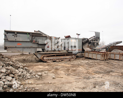 Il frantumatore mobile SBM è un pezzo di macchinari pesanti utilizzati nelle industrie edili e minerarie. È progettato per frantumare grandi quantità di materiali come roccia, pietra e calcestruzzo in loco, riducendo la necessità di trasporto e aumentando l'efficienza. Foto Stock