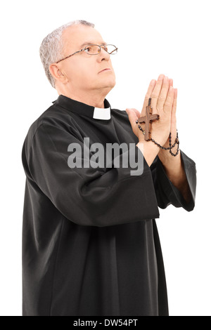 Sacerdote matura in possesso di una croce di legno e la preghiera a Dio Foto Stock