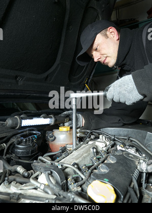 Meccanico automatico di sostituzione delle candele a incandescenza nella vettura motore diesel utilizzando la candela chiave Foto Stock
