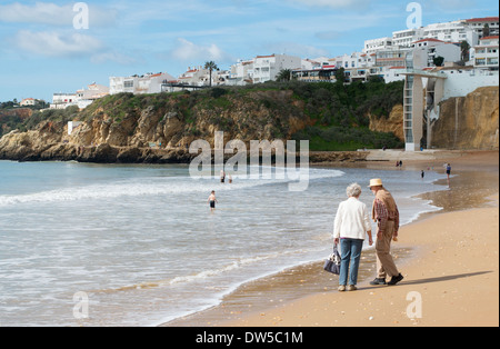 Coppia senior a piedi lungo la spiaggia di Albufeira, Algarve, Portogallo, Europa Foto Stock