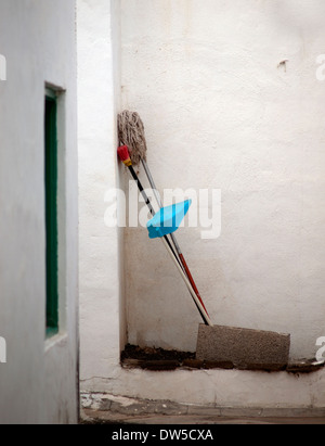 Gli attrezzi di pulizia appoggiato contro una parete in una stradina secondaria e in spagnolo Foto Stock