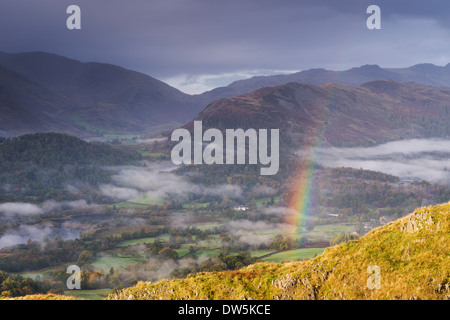 Rainbow su Nebbia avvolta paesaggio, Elterwater, Lake District, Cumbria, Inghilterra. In autunno (ottobre 2012). Foto Stock