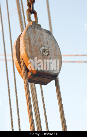 Puleggia di legno con corde contro il cielo blu Foto Stock