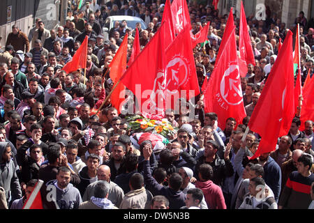 Birzeit, West Bank, Territorio palestinese. 28 feb 2014. Lutto palestinese portano il corpo di Mutaz Washaha, 22, un militante del Fronte Popolare per la liberazione della Palestina (PFLP), dalla Cisgiordania città di Birzeit, a nord di Ramallah, durante il suo funerale 28 febbraio 2014. Mutaz è stato ucciso dalle forze israeliane che presumibilmente utilizzato missili e bulldozer sulla sua casa il 27 febbraio 2014 Credit: Issam Rimawi APA/images/ZUMAPRESS.com/Alamy Live News Foto Stock