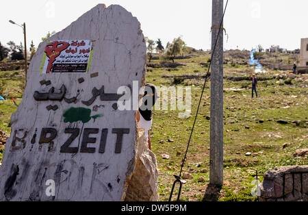 Birzeit, West Bank, Palestina - 28 Febbraio 2014: una gioventù palestinese durante scontri al checkpoint di Atara, a nord della Cisgiordania città di Ramallah. Gli scontri scoppiati venerdì dopo il funerale di Muataz Washaha, che è stato ucciso dalle forze israeliane giovedì nella sua casa nella West Bank village di Birzeit, nei pressi di Ramallah. (Foto di Abdalkarim Museitef/Pacific Press/Alamy Live News) Foto Stock