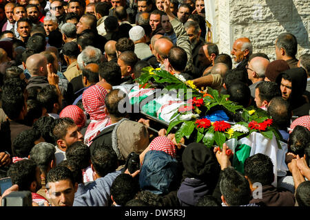 Birzeit, West Bank, Palestina - 28 Febbraio 2014: i palestinesi portano il corpo di Muataz Washaha durante il suo funerale nella West Bank village di Birzeit, vicino a Ramallah . Le forze israeliane hanno aperto il fuoco e ucciso Washaha, che cercavano di cattura in Cisgiordania occupata giovedì dopo l' uomo era asserragliato dentro la sua casa. (Foto di Abdalkarim Museitef/Pacific Press/Alamy Live News) Foto Stock