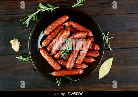 Salsicce affumicate sul tavolo di legno, vista dall'alto Foto Stock