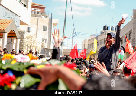Birzeit, West Bank, Palestina - 28 Febbraio 2014: i palestinesi portano il corpo di Muataz Washaha durante il suo funerale nella West Bank village di Birzeit, vicino a Ramallah . Le forze israeliane hanno aperto il fuoco e ucciso Washaha, che cercavano di cattura in Cisgiordania occupata giovedì dopo l' uomo era asserragliato dentro la sua casa. (Foto di Abdalkarim Museitef/Pacific Press/Alamy Live News) Foto Stock