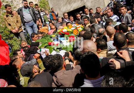 Birzeit, West Bank, Palestina - 28 Febbraio 2014: i palestinesi portano il corpo di Muataz Washaha durante il suo funerale nella West Bank village di Birzeit, vicino a Ramallah . Le forze israeliane hanno aperto il fuoco e ucciso Washaha, che cercavano di cattura in Cisgiordania occupata giovedì dopo l' uomo era asserragliato dentro la sua casa. (Foto di Abdalkarim Museitef/Pacific Press/Alamy Live News) Foto Stock