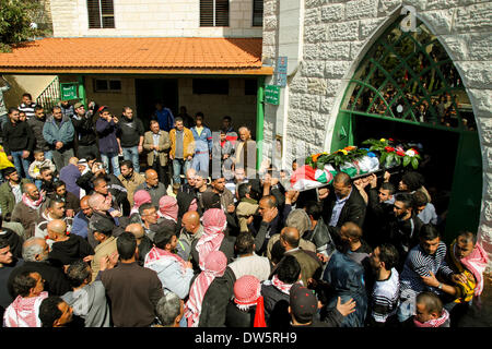 Birzeit, West Bank, Palestina - 28 Febbraio 2014: i palestinesi portano il corpo di Muataz Washaha durante il suo funerale nella West Bank village di Birzeit, vicino a Ramallah . Le forze israeliane hanno aperto il fuoco e ucciso Washaha, che cercavano di cattura in Cisgiordania occupata giovedì dopo l' uomo era asserragliato dentro la sua casa. (Foto di Abdalkarim Museitef/Pacific Press/Alamy Live News) Foto Stock
