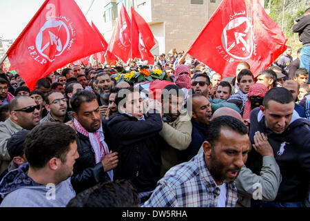 Birzeit, West Bank, Palestina - 28 Febbraio 2014: i palestinesi portano il corpo di Muataz Washaha durante il suo funerale nella West Bank village di Birzeit, vicino a Ramallah . Le forze israeliane hanno aperto il fuoco e ucciso Washaha, che cercavano di cattura in Cisgiordania occupata giovedì dopo l' uomo era asserragliato dentro la sua casa. (Foto di Abdalkarim Museitef/Pacific Press/Alamy Live News) Foto Stock