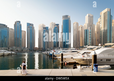 Un arabo giovane a piedi nella Marina di Dubai, il Jumeirah area di torri e grattacieli di Dubai e sullo skyline, Emirati Arabi Uniti, Emirati Arabi Uniti Foto Stock