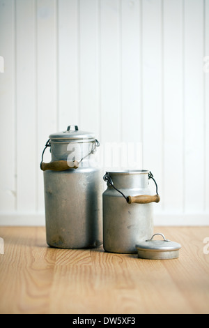 Vintage lattine di latte sul pavimento in legno Foto Stock