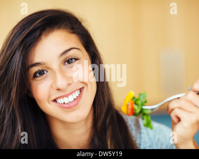 Attraente giovane donna insalata mangiare Foto Stock