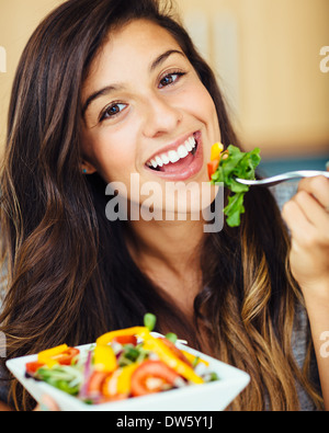 Attraente giovane donna insalata mangiare Foto Stock