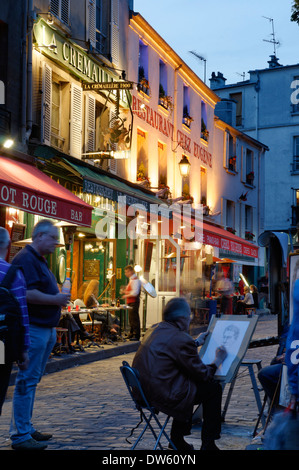 Un artista al lavoro in Place du Tertre, Montmartre, Parigi di notte Foto Stock