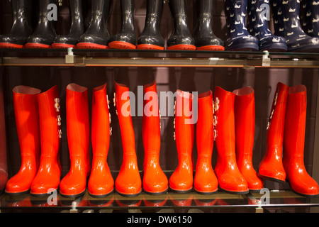 Arancione e nero wellies in vendita. Wellington o stivali di gomma le vendite sono aumentate a causa di un inverno umido nel Regno Unito. Foto Stock