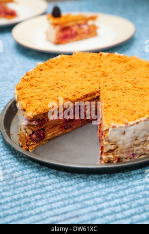 Torta di miele con ciliegie in zucchero a velo Foto Stock