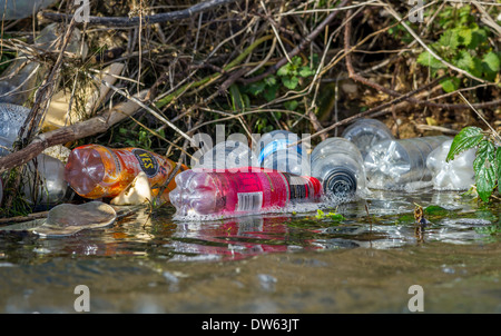 Scartare le bottiglie di plastica inquinano le rive di un fiume. Foto Stock