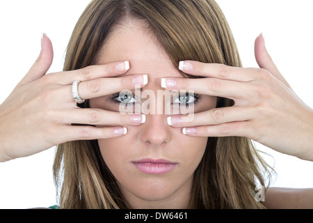 Triste giovane donna del peering attraverso le dita Foto Stock