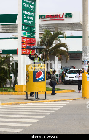 Un giovane peruviano poliziotta dirigere il traffico in corrispondenza di un incrocio nella città di Chiclayo nel nord del Perù Foto Stock