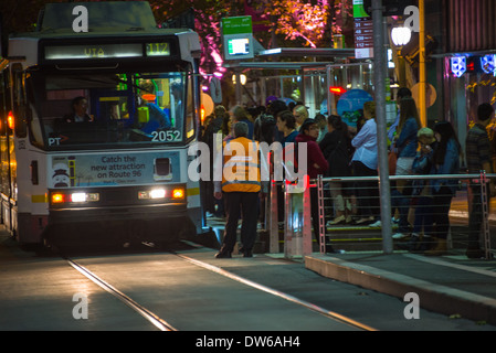 Tram di Melbourne on Collins Street in una trafficata sabato sera Pubblica folla Foto Stock