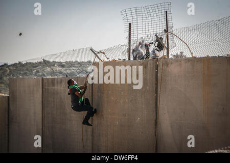 Cisgiordania, Territori palestinesi. 28 feb 2014. Oggi segnato il nono anniversario del Bil'nel villaggio di manifestazione settimanale contro il muro di apartheid e l'occupazione della Palestina. La manifestazione pubblica non violenta ha visto oltre mille sostenitori compresi i Palestinesi, internazionali e israeliani gli attivisti in piedi in solidarietà con il villaggio. In 9 anni dal Bil'in iniziò la resistenza pacifica campagna, il villaggio è diventato un simbolo in tutto il mondo come il centro di una resistenza non violenta contro l'occupazione israeliana. In questo momento più di duemila persone tra internatio Foto Stock