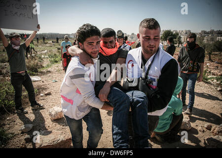 Cisgiordania, Territori palestinesi. 28 feb 2014. Oggi segnato il nono anniversario del Bil'nel villaggio di manifestazione settimanale contro il muro di apartheid e l'occupazione della Palestina. La manifestazione pubblica non violenta ha visto oltre mille sostenitori compresi i Palestinesi, internazionali e israeliani gli attivisti in piedi in solidarietà con il villaggio. In 9 anni dal Bil'in iniziò la resistenza pacifica campagna, il villaggio è diventato un simbolo in tutto il mondo come il centro di una resistenza non violenta contro l'occupazione israeliana. In questo momento più di duemila persone tra internatio Foto Stock