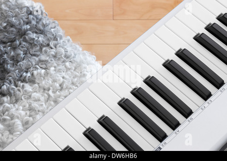 Close-up di pianoforte elettrico chiavi e sedia. Foto Stock