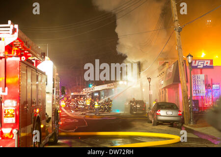 1 marzo 2014 - Huntington, New York, Stati Uniti - Un grande incendio divampa nel cuore del villaggio di Huntington, su New York Avenue. I vigili del fuoco provenienti da molte città vicine di contea di Suffolk, Long Island, ed enormi nuvole di fumo illuminato il cielo notturno per blocchi. Credito: Ann e Parry/Alamy Live News Foto Stock