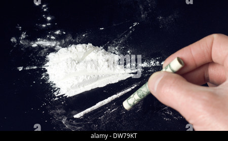 La cocaina heap e mano umana con laminati dollar Foto Stock
