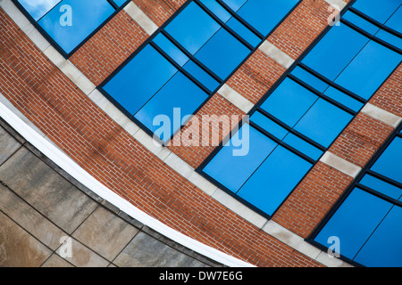 Immagine astratta di una forma curva ufficio torre in mattoni rossi e vetro. Foto Stock