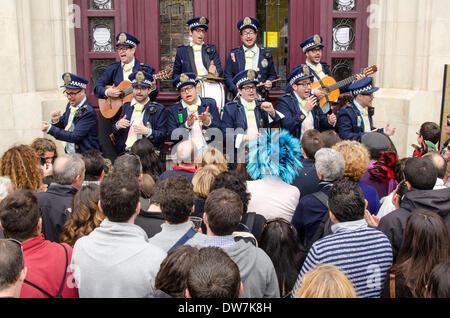Cadiz, Spagna. 2 marzo 2014. Un raggruppamento di Carnevale (Costume della polizia) canta in strada il loro repertorio (tipico Carnevale canzoni, appositamente composta ogni anno dai raggruppamenti per questa festa). Cadice Carnevale - Domenica 2 marzo Foto Stock