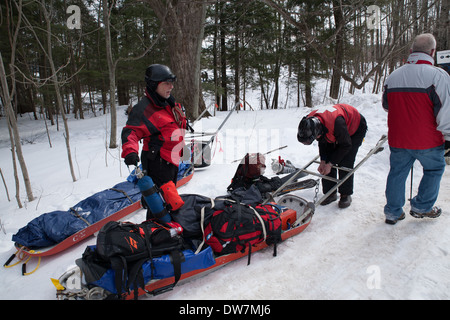 Due membri del Thunderbolt Ski Patrol controllare il loro tirare gli sled dopo il Thunderbolt annuale Ski Run in Adams MA. Foto Stock