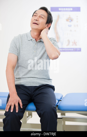 Paziente Senior tenendo la sua dolorosa collo Foto Stock