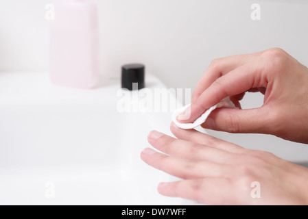 Donna con acetone per rimuovere lo smalto per unghie dal suo le unghie Foto Stock