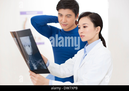 Medico guardando immagine a raggi x con paziente Foto Stock