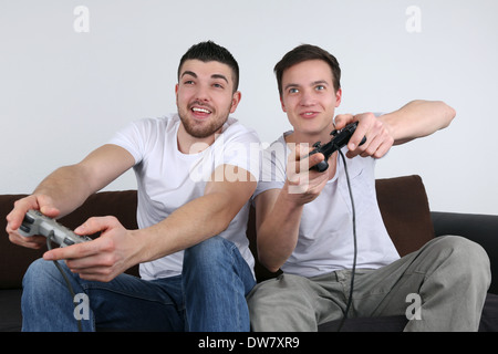 Due giovani uomini per divertirsi durante la riproduzione di video giochi Foto Stock