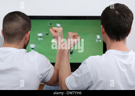 I giovani a guardare il calcio o il calcio in tv Foto Stock