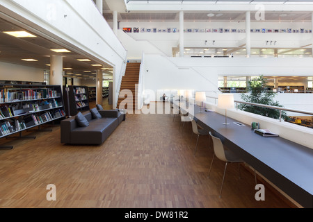 Genk biblioteca pubblica, a Genk, in Belgio. Architetto: Claude Vasconi, 2008. Primo piano con divani in pelle marrone, librerie e scrivania, un Foto Stock