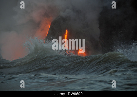 Onde si infrangono e lava dal vulcano Kilauea che fluisce nell'oceano, Parco Nazionale dei Vulcani delle Hawaii, Big Island, Hawaii, STATI UNITI D'AMERICA Foto Stock