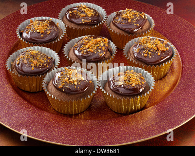 Oro sormontato tortini di cioccolato Foto Stock