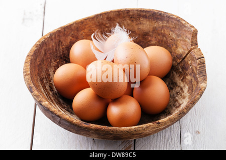 Le uova in una terrina su sfondo di legno Foto Stock