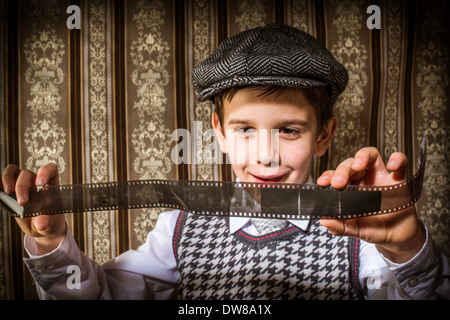 Bambino considerato analogico pellicola fotografica. Abbigliamento vintage e lo sfondo Foto Stock