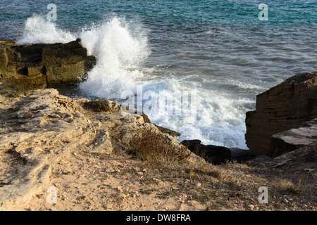 Si infrangono onde di schiuma di mare a Ses Covetes, Maiorca, isole Baleari, Spagna. Foto Stock